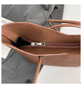 Detail shot of the secure metal zipper closure on this brown lychee texture tote bag