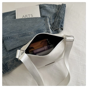Vue intérieure d'un sac bandoulière blanc minimaliste montrant la capacité et les boucles