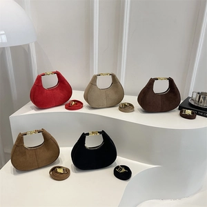 Five assorted colors of suede crescent handbags with gold hardware and shoulder straps