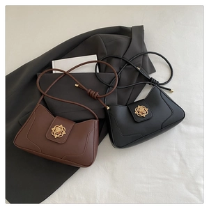 Détail rapproché de sacs sous les aisselles en cuir marron et noir avec boucles dorées