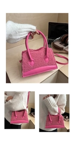 Detail view of mini pink plush handbag with leather trim on a wooden desk setup