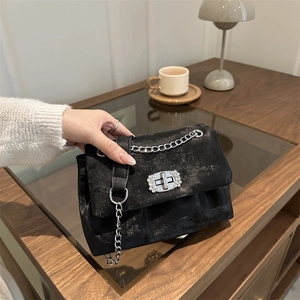 Sac bandoulière élégant en velours noir avec chaîne et boucle en cristal sur bois
