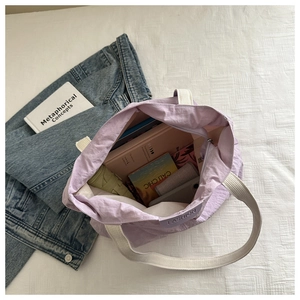 Detail view of spacious light purple nylon tote bag showing interior storage capacity
