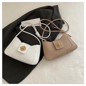 Détail de sacs bandoulière en cuir kaki et blanc avec fermoirs en forme de rose dorée