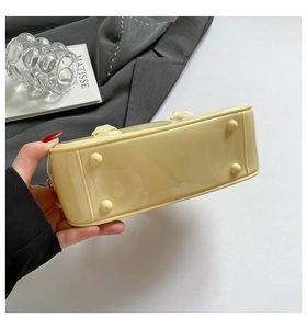 Detailed view of cream yellow handbag base with four protective metal feet studs