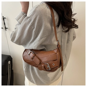 Brown faux leather underarm bag featuring vintage buckles and silver eyelet details