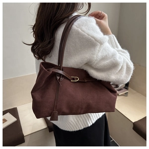 Detail view of large dark brown suede tote bag featuring sleek golden buckle strap accents