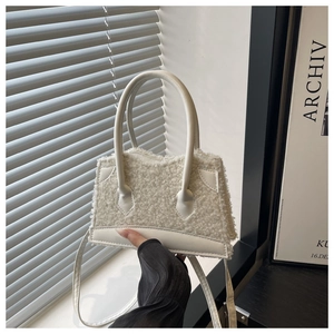 Close-up of white plush faux fur mini tote bag with leather handles and shoulder strap