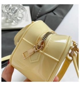 Detailed close-up of smooth light yellow silicone bag with high-quality golden metal zipper