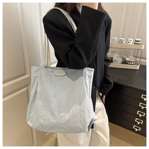 Gros plan du sac fourre-tout bleu clair plissé avec petite étiquette FASHION en haut
