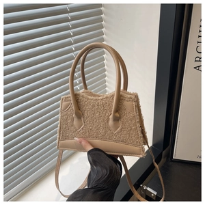 Detail of beige faux shearling handbag with textured plush surface and leather straps