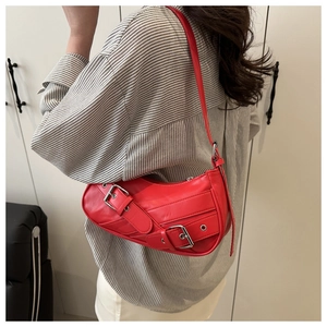 Detail view of red faux leather baguette bag with silver buckles and Y2K strap design