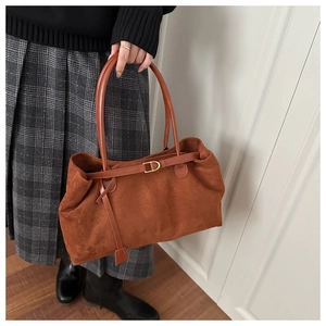 Detail of caramel suede tote bag featuring sleek leather straps and gold D-ring hardware