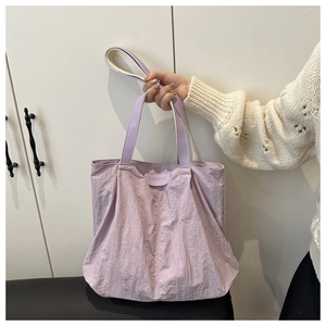 Gros plan du sac cabas en nylon lilas avec texture plissée et sangle réglable