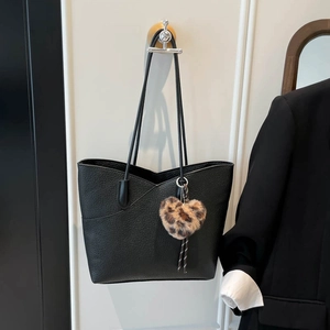 Minimalist black pebble leather tote bag with a trendy leopard heart plush keychain