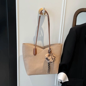 Chic beige leather tote bag with leopard print charm and dark brown shoulder straps