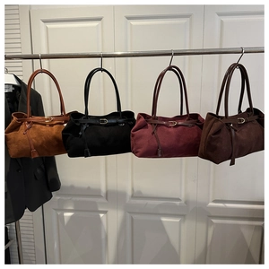 Detail showing the suede tote bags in brown, black, burgundy, and dark coffee with buckles