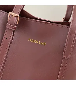 Close-up of wine red faux leather texture with gold Fashion & Bags lettering and strap buckle