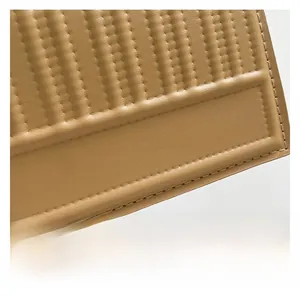 Macro shot of vertical quilted faux leather texture with branded golden lettering on bag