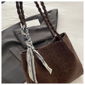 Detail einer Leopard-Tote-Bag mit geflochtenen Griffen und Seidentuch auf Blazer