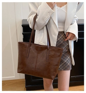 Close-up of vintage brown oil wax leather tote bag with elegant vertical stitching detail