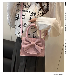 Detailed view of pink sparkling rhinestones and oversized bow on the luxury evening bag