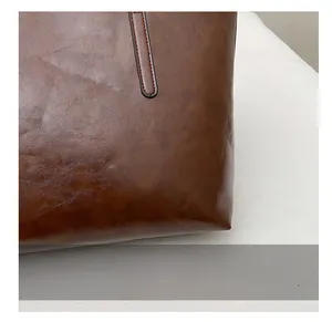 Close-up of brown PU leather tote with textured finish and durable stitching detail