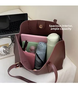 Spacious interior of dark red leather tote bag holding a tablet, bottle, and wallet