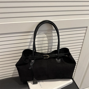 Minimalist black tote bag with long handles and golden buckle on white background