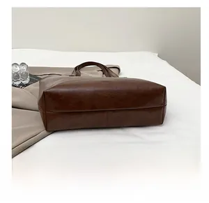 Detailed view of the reinforced wear-resistant base on this large brown PU leather tote bag