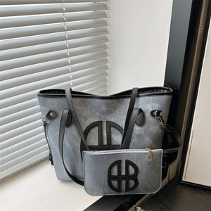 Light blue denim tote bag with letter logo and matching pouch set with black leather trim