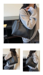Detail of matte black tote bag with vertical stitching and gold lettering on the leather