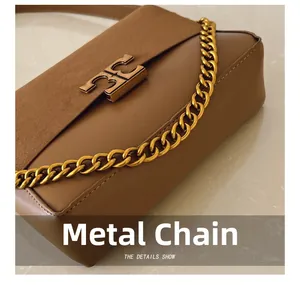 Detail of gold chain strap and double-T clasp on brown leather and suede crossbody bag
