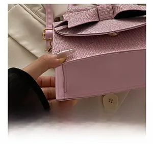 Detail showing precise stitching on pink sequin clutch bag with elegant bow accent