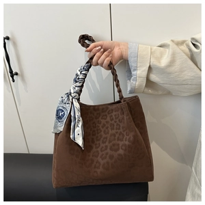 Detail der Totebag mit Leopardenmuster, gewebtem Griff und dekorativem Seidenschal-Element