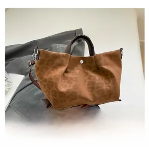 Detail of leopard print tote bag with ruched texture and vintage brown handle