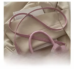 Detail of pink bow handbag showing adjustable shoulder strap and woven glitter texture