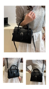 Detail view of black matte leather bag with silver horseshoe buckle and top handle