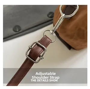Close-up of adjustable brown leather shoulder strap with silver buckle and hardware