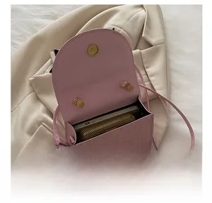 Interior view of small square crossbody bag showing phone and wallet storage capacity