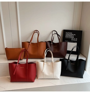 Collection of minimalist faux leather tote bags in various colors on a marble display