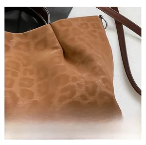 Macro shot showing leopard print fabric texture and brown leather strap with D-ring