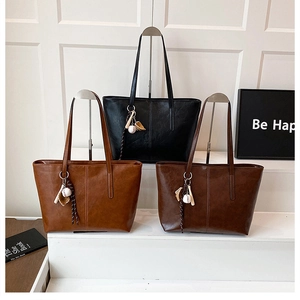 Detailed view of three PU leather tote bags in black, light brown, and dark brown colors