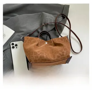 Detail of leopard print tote bag with magnetic closure and leather trim showing capacity