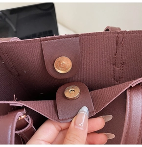 Détail macro du sac cabas bordeaux avec fermoir magnétique doré et doublure texturée