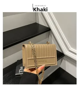 Detail of khaki quilted PU leather handbag with gold chain and branded metal logo