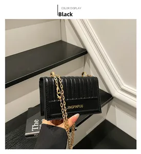 Detailed view of the black crossbody bag featuring vertical quilting and gold chain strap