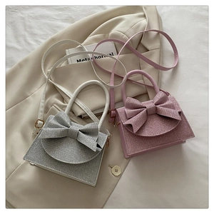 Detail der silbernen und rosa Schleifen-Minibags mit Glitzer und Goldbeschlägen