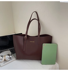 Détail du grand sac cabas en cuir PU marron foncé avec inscription dorée élégante