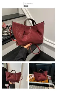 Detail of red leopard print tote bag with pleated texture and stylish metal buckle closure
